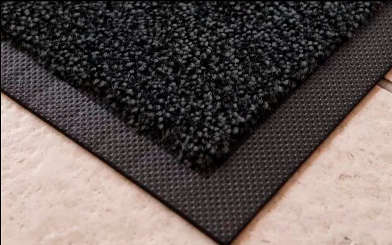 Close up of the corner of the black cotton soaker mat. The Mat Group UK.