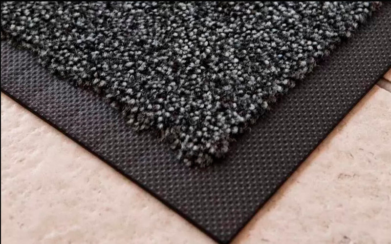 Corner image of the black and white cotton soaker entrance mat with rubber edging. The Mat Group UK.