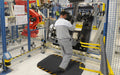 Insitu image of a worker in a production line factory using the anti-fatigue Hog Heaven Mat with Chevron Safety Boarders.