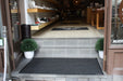 Insitu image of the Charcoal Waterhog Mat at the entrance of a retail space. The Mat Group UK.